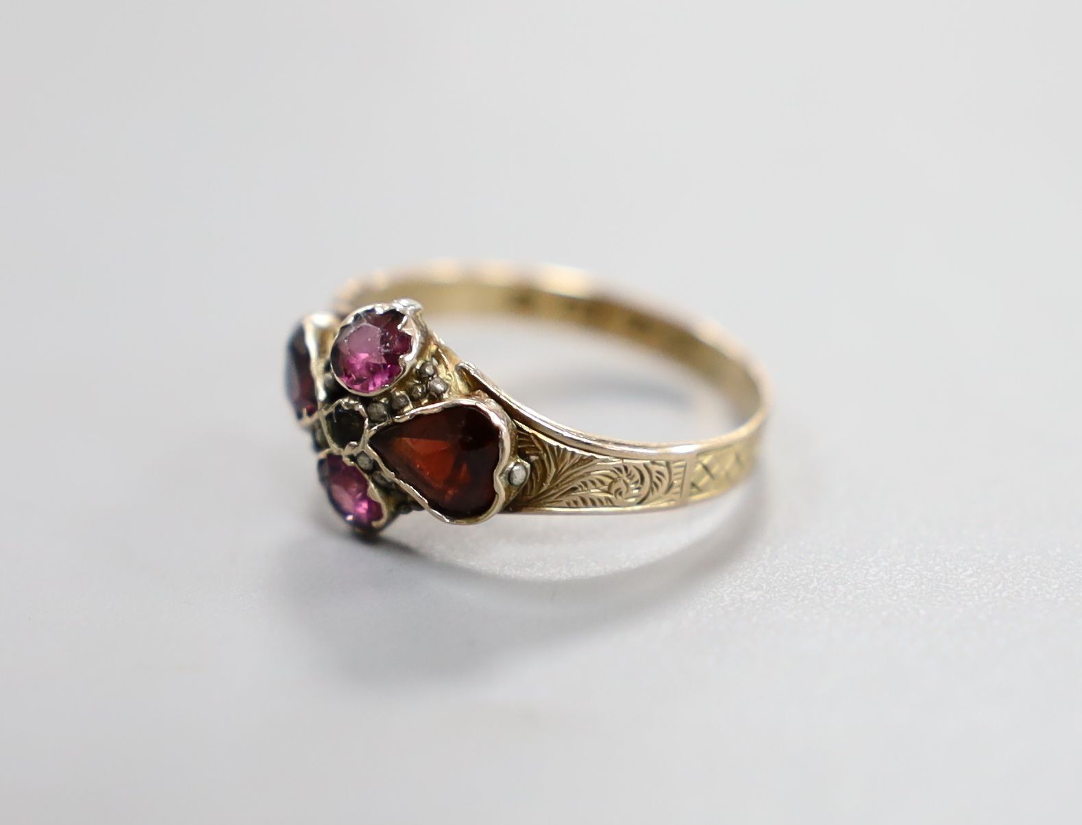 A Victorian 12ct gold and four stone garnet and amethyst set dress ring, size O, gross 1.7 grams.
